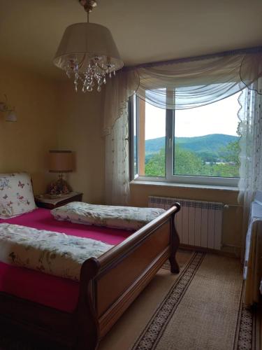 a bedroom with a bed and a large window at Widoczek in Polańczyk