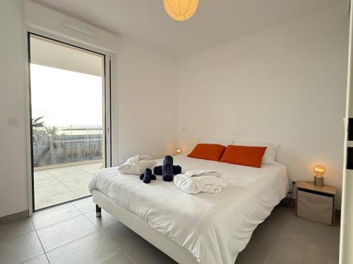 une chambre avec un grand lit blanc avec des serviettes dessus dans l'établissement Valras-Loc Archipel Capri - Murmures des Vagues, à Valras-Plage