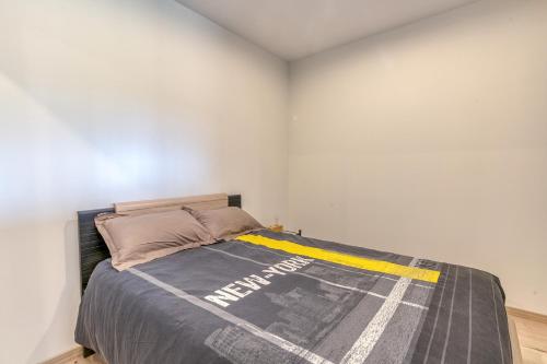 a bedroom with a bed with a blanket on it at La source Amélie in Saint-Pancrasse