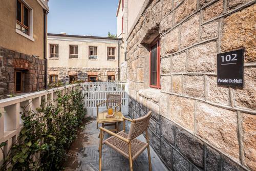 a table and chairs sitting on a balcony next to a building at TUIWA Garden Holiday Villa in Qingdao