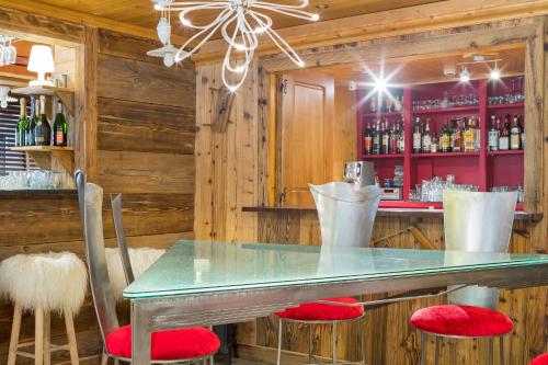 a bar with a glass table and red chairs at le A by neige et roc in Morzine