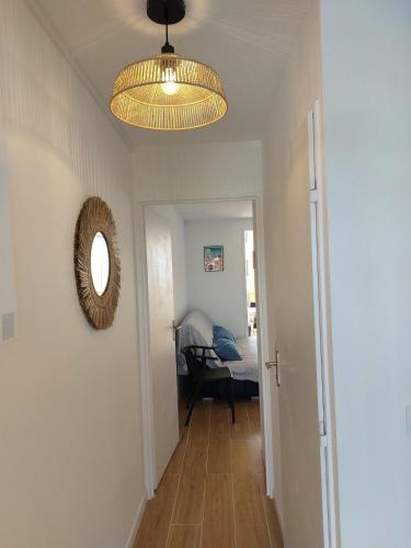 a hallway with a ceiling light and a mirror at Appart avec loggia en front de mer et superbe vue in Le Barcarès