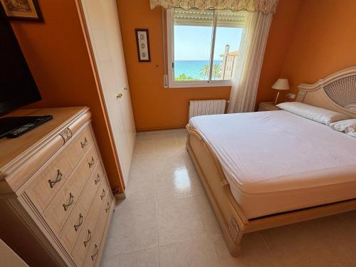 a bedroom with a bed and a window with the ocean at Penthouse w/ sea view, pool & beach in Calafell