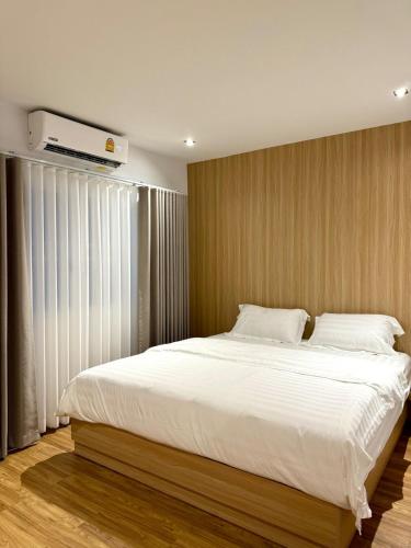 a bedroom with a large bed with white sheets at Luana Hatyai house in Hat Yai