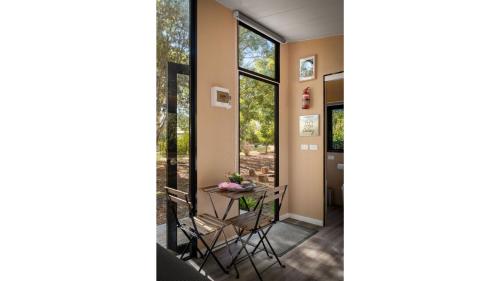 a hallway with a table and chairs in a house at Manna Gum Retreat by Tiny Away in Allansford