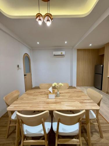 a dining room with a wooden table and chairs at Luana Hatyai house in Hat Yai