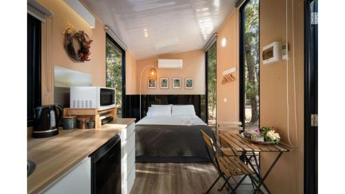 a bedroom with a bed and a desk with a television at Manna Gum Retreat by Tiny Away in Allansford
