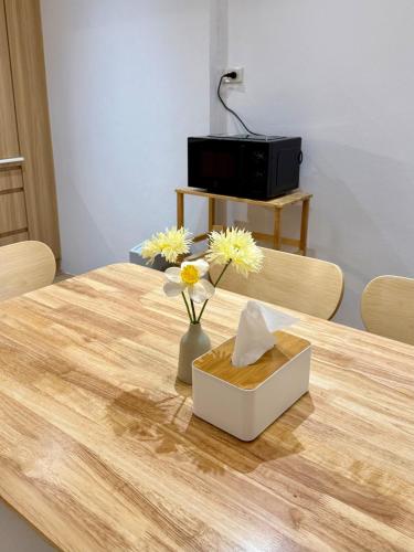 a wooden table with a vase of flowers on it at Luana Hatyai house in Hat Yai