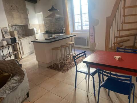 a kitchen with a counter and a table and chairs at Grands appartements dans la vieille ville in Périgueux