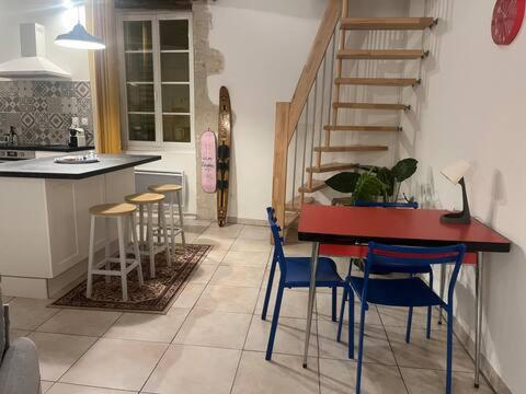 a kitchen with a table and chairs and a staircase at Grands appartements dans la vieille ville in Périgueux