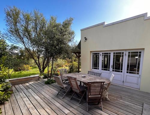 a wooden deck with a table and chairs on it at The Happy Place, private cottage with rustic pool in Van Wyksdorp