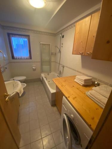 a bathroom with a washing machine and a sink at Apartments Nadia in San Vigilio Di Marebbe