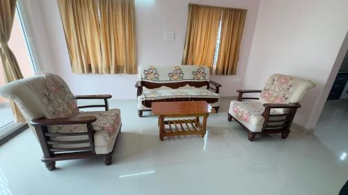 a living room with three chairs and a couch at Yashwithaa Homestay Tirupati - New Hill View Apartments with Balcony, AC, WiFi, TV in Tirupati