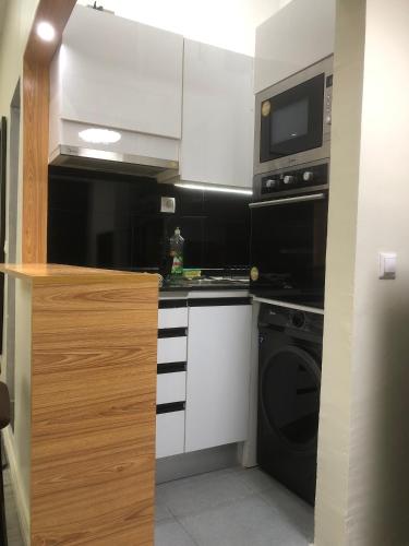 a kitchen with a stove and a microwave at Mutamba Prime Stay in Luanda