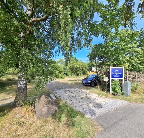 a car parked on a road next to a sign at The FIG Studio - "Den Gule Svane" Guest House - near Rønne & Beach in Rønne