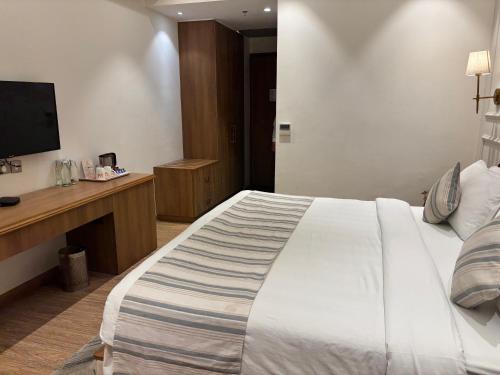 a hotel room with a large bed and a television at The BellaVista Hotel Chandigarh Panchkula in Chandīgarh