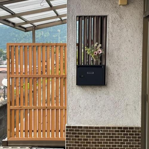 a wooden fence with a flower box on a building at Guest House KANOKO in Nakatsugawa