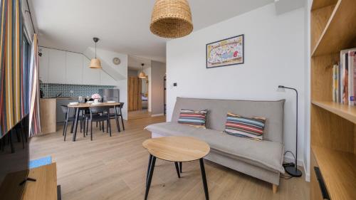 a living room and kitchen with a couch and a table at Bałtycka Oaza, Sun & Snow in Tupadły