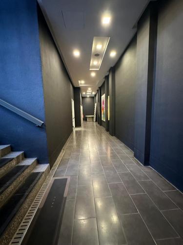 a long hallway with stairs and a blue wall at Bukit Bintang KLCC Fairlane suite by Rose in Kuala Lumpur