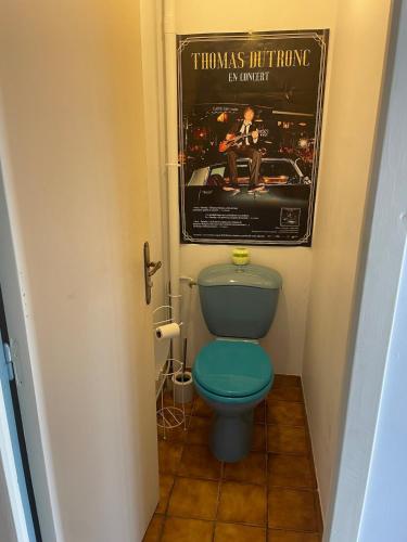 une salle de bain avec des toilettes bleues et une affiche de film dans l'établissement Country house for 6 people, à Saint-Hilaire-de-Court