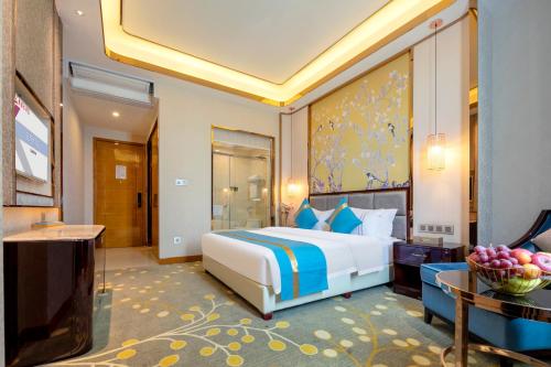 a bedroom with a king sized bed and a table at Lugang Hotel in Guangzhou
