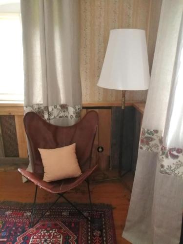 a living room with a chair and a lamp at Bodenschmiede in Hopfgarten im Brixental