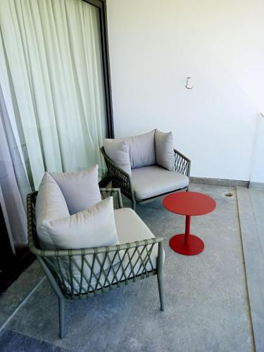 a living room with two chairs and a red table at The Red Residence North Coast Egypt in Mājid Abū Zayd