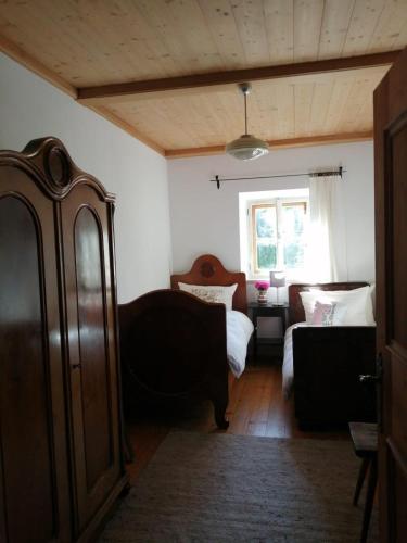 a bedroom with a couch and a bed and a window at Bodenschmiede in Hopfgarten im Brixental