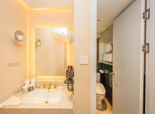 a bathroom with a sink and a toilet at TUIWA Garden Holiday Villa in Qingdao