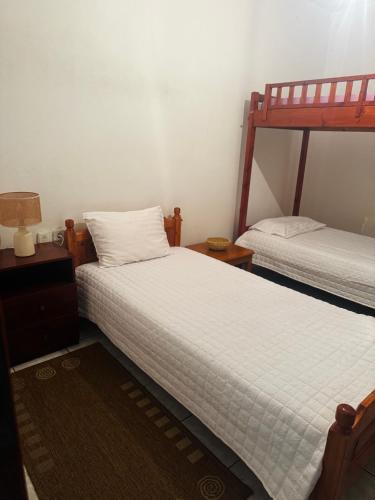 a bedroom with two beds and a night stand with a lamp at Elisabeth Apartment in Akoumia