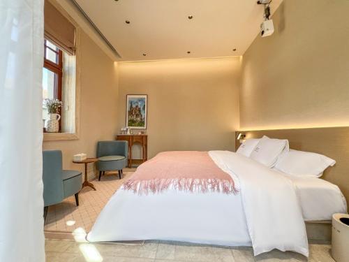 a bedroom with a large white bed and a window at TUIWA Garden Holiday Villa in Qingdao