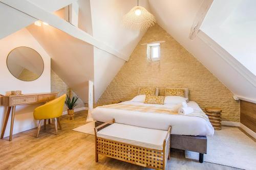 Maison Spa et Sauna, Cœur de la Normandie في Ranville: غرفة نوم بسرير كبير في العلية