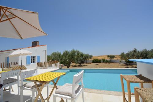a villa with a pool and a table and chairs at LALOU Casinhas B&B in Mértola