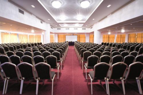 an empty room with rows of chairs in a building at Domotel Xenia Volos in Volos