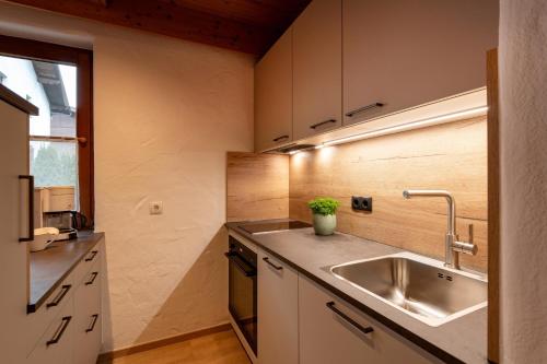 a small kitchen with a sink and a window at Ferienwohnung Kober in Hopfgarten im Brixental