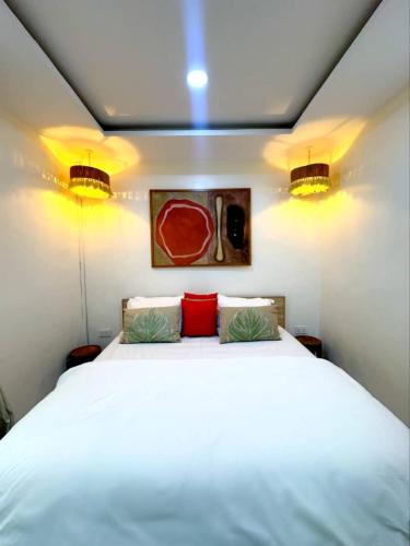 a bedroom with a white bed with two red pillows at The Cozy Corner in New Lagos