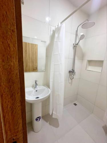 a white bathroom with a sink and a shower at The Cozy Corner in New Lagos