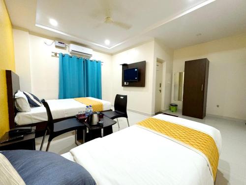 a hospital room with two beds and a desk at Harsha Comforts in Chikmagalūr