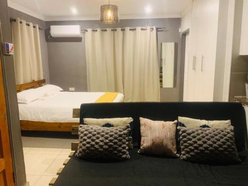 a living room with a couch and a bed at L & B Homes in Maun