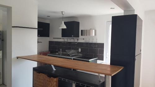 une cuisine avec des armoires noires et un comptoir en bois dans l'établissement Maison cosy avec jardin, à Pornichet