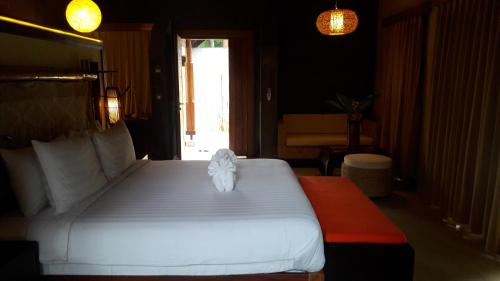 a bedroom with a large white bed in a room at Namkat Yorla Pa Resort in Ban Kat