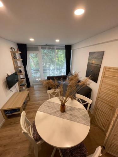 a dining room with a white table and chairs at Preilos39 in Preila
