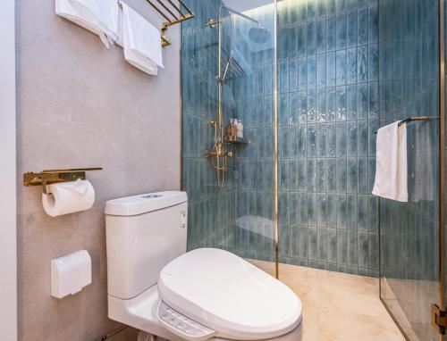 a bathroom with a toilet and a glass shower at TUIWA Garden Holiday Villa in Qingdao
