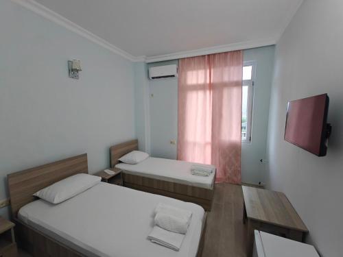 a small room with two beds and a window at Hotel Horizont! in Batumi