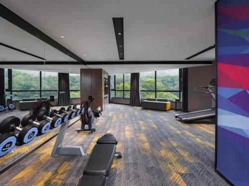 a gym with treadmills and chairs in a building at Hampton by Hilton Dongguan Fenggang in Dongguan