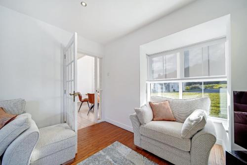 a living room with two chairs and a window at 29 Fintra Bay with direct access to the beach in Saint Catherines