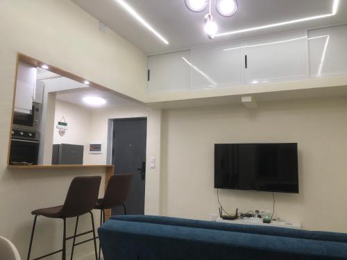 a living room with a blue couch and a flat screen tv at Mutamba Prime Stay in Luanda