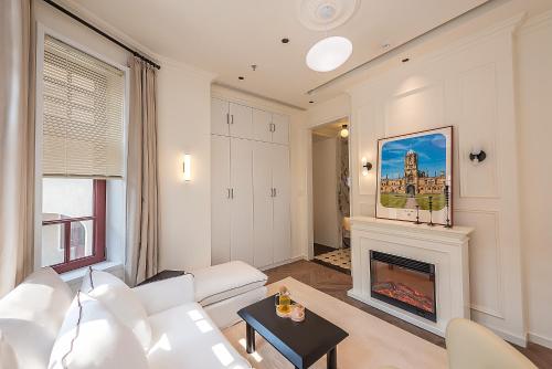 a living room with a white couch and a fireplace at TUIWA Garden Holiday Villa in Qingdao