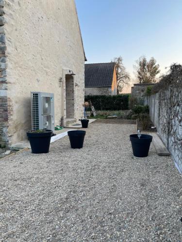 a courtyard with pots on the ground next to a building at Les sereins 