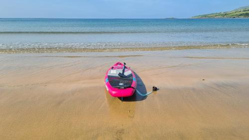 a pink kayak sitting on the sand on a beach at 29 Fintra Bay with direct access to the beach in Saint Catherines